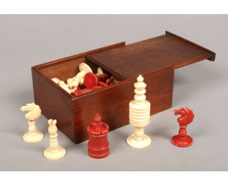 An early 20th century Indian export bone and ivory polychrome chess set in mahogany box with sliding lid. King pieces 9.25cm.