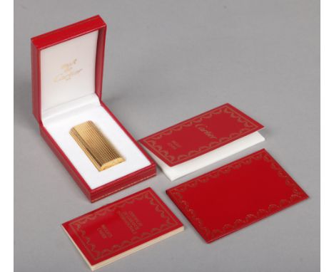 A Cartier must de gold plated lighter, with knurled grip, in box and with papers.Condition report intended as a guide only.Me
