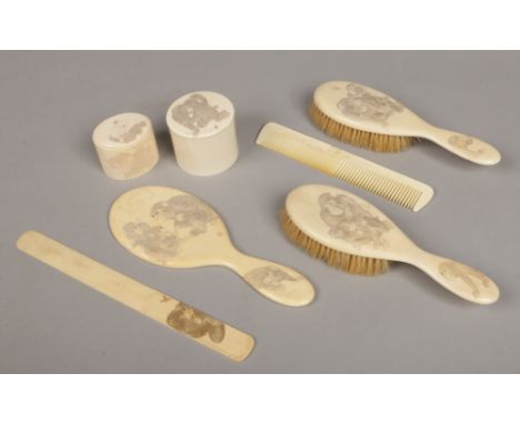 A Japanese Meiji period carved ivory six piece dressing table set and a page turner. Each decorated in light relief with chim