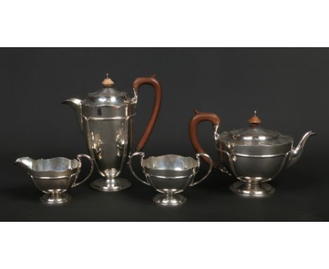 A George V silver four part tea service by Adie Bros. Ltd. With scalloped tops, piped cartouches and of heavy gauge. Comprisi