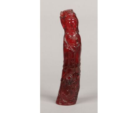 A Chinese carved cherry amber coloured statue of Guanyin. Dressed in flowing robes and holding a lily stem. 636 grams, 27cm.