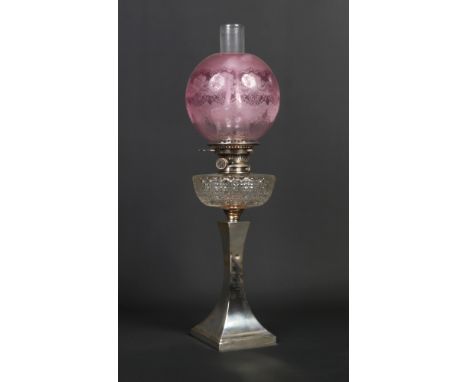 An Edwardian silver based oil lamp of square tapering form. With etched cranberry tint shade, cut glass font and having Hinks