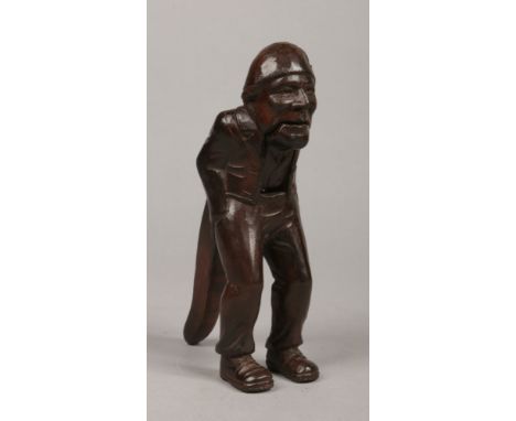 A 19th century carved Swiss nut cracker. Formed as a standing man wearing a nightcap and with his hands in his pockets, 19.5c