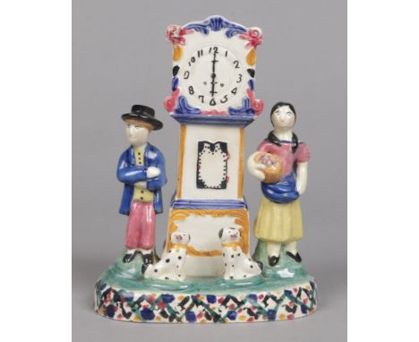 A 19th century prattware money box, Mexborough, Yorkshire. Formed as a longcase clock flanked by a figure of a lady and gent 