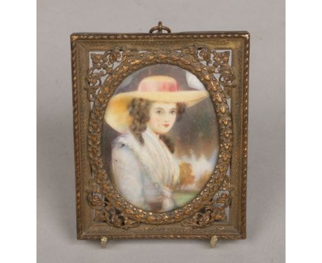 An early 20th century ivory portrait miniature in pierced brass frame depicting a seated lady.&nbsp;