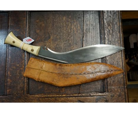 A large kukri and leather sheath, with ivory scales, 31cm blade. 