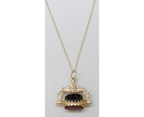 A yellow metal mounted spinning fob set with carnelian, onyx and bloodstone, the loop marked 9ct, on a fine 9ct gold chain, 6