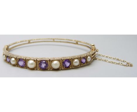 A 9ct gold, amethyst and pearl bangle, 11.8g, 5.9 x 5.1cm