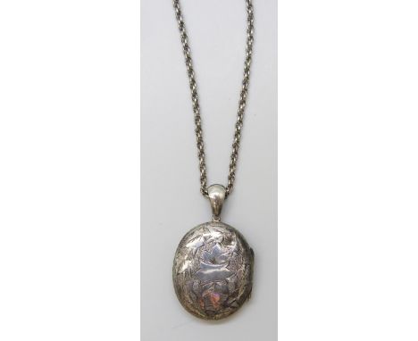 A Victorian white metal locket, 14g, 5cm, on a long chain (Some dents to locket. Chain unmarked)