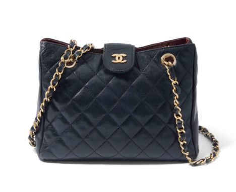 Chanel, Schultertasche1986–88. Aus dunkelblauem, gestepptem Leder. Zwei lange, lederdurchflochtene Kettenriemen aus goldfarbe