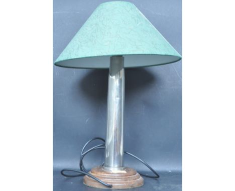 A vintage 20th century table lamp having a support made out a shell casing raised on a stepped wooden circular base. Measures