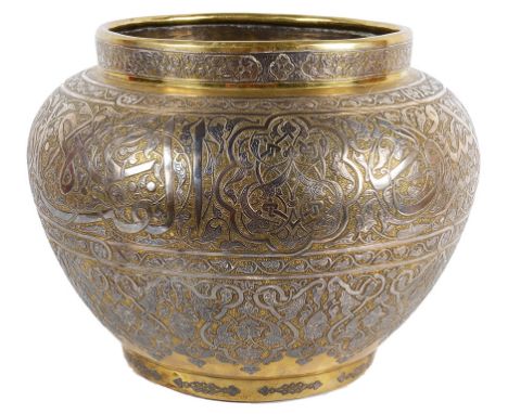 A Persian brass and silver bowl18th/19th centuryElegantly decorated with Arabic calligraphy and leafy scrolls.D 34 cm CONDITI