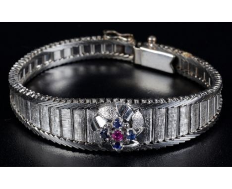 A White Gold Ruby and Sapphire Bracelet:Hallmarked 18ct in white gold, full articulated bracelet, the central floral design s