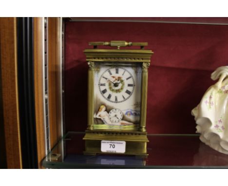 A brass and porcelain hand painted carriage clock decorated with nude females