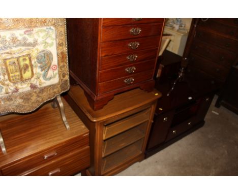 An oak veneered three drawer chest; together with an Ercol glazed cabinet 