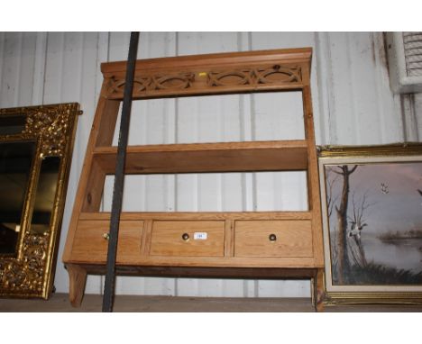 A stripped pine hanging wall shelf fitted three drawers below