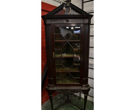 A Chippendale revival mahogany corner cabinet on stand, possibly Irish, architectural pediment above a deep frieze and an ast