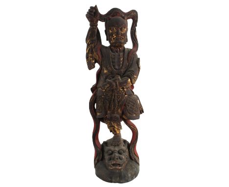 Chinese Painted and Gilt Wood Buddhist Guardian Ming Dynasty. The gilt figure standing atop a horned demon head lying on a mo