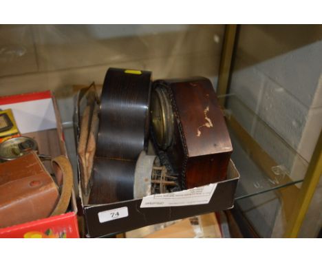 A box containing two mantel clocks; a clock movement; and a pair of butter pats 