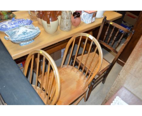 A pair of light Ercol elm stick back kitchen chairs; and a cane seated spindle back chair 