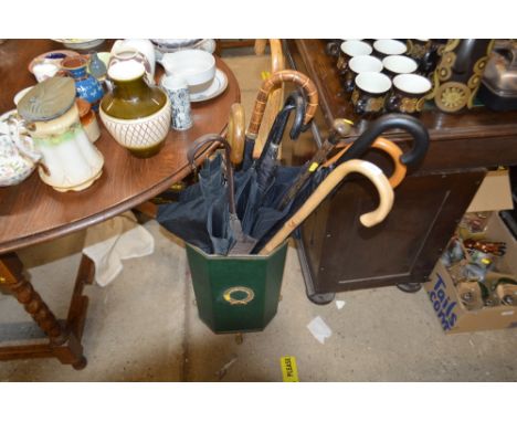 A stick stand and contents of umbrellas and walking sticks