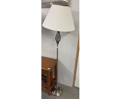 A varnished twisted-head design standard lamp with shade