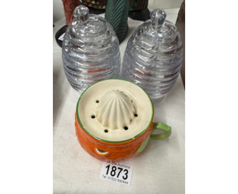 A pair of glass beehive honey pots and a vintage ceramic fruit juicer