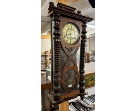 A double regulator wall clock with key, pendulum and weights.