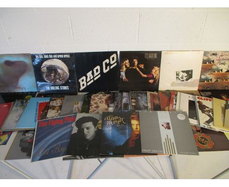 A collection of 12" vinyl records including Pink Floyd, Bad Company, Rolling Stones, Santana, Simon &amp; Garfunkel, Wings, F