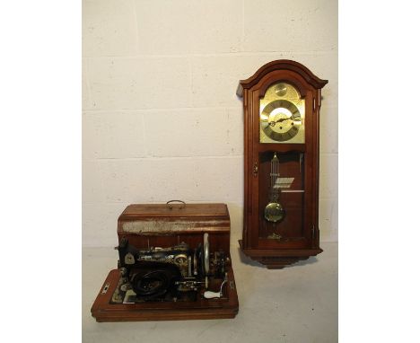 A vintage Frister and Rossmann electric sewing machine and an AMS wall clock