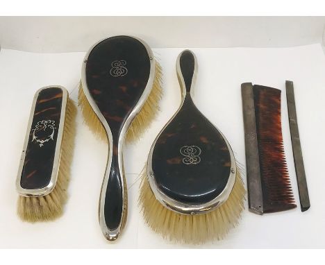 Three silver and tortoiseshell brushes along with a comb