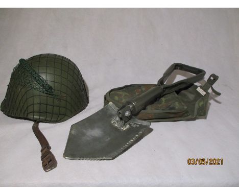 A military helmet along with a folding entrenching tool in canvas carry case
