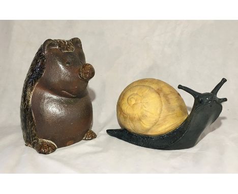 A large ceramic snail and a large hedgehog garden ornament