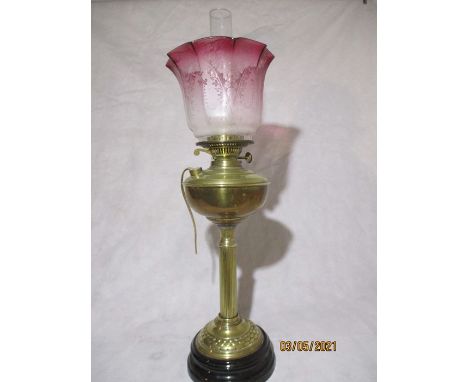 A brass oil lamp ( converted) with cranberry glass shade