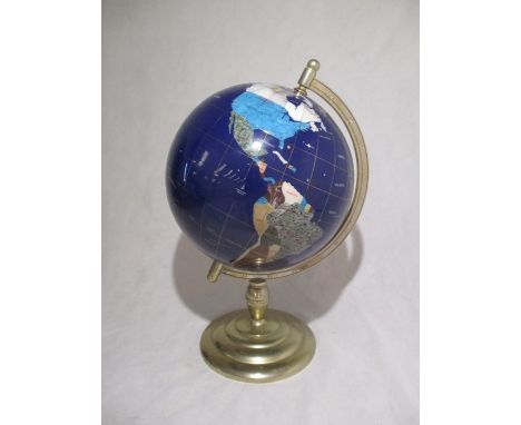 A gemstone globe on brass base