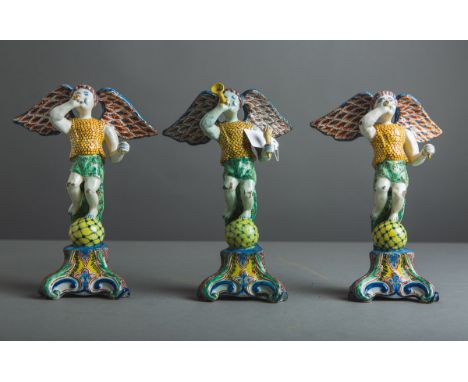 3-teiliges Konvolut von Fayence-Figuren (18. Jh.), Darst.: Engel m. Fanfaren aufvolutenartigen Postamenten stehend, polychrom