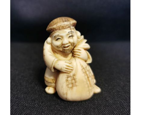 NETSUKE: "Händler / Bauer mit Reissack", detailreich und auch unter dem Stand geschnitzt und partiell farbig akzentuiert. H. 