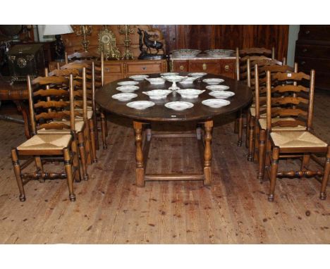 Good quality oval oak dining table and eight rush seated ladder back dining chairs including pair carvers, probably Titchmars