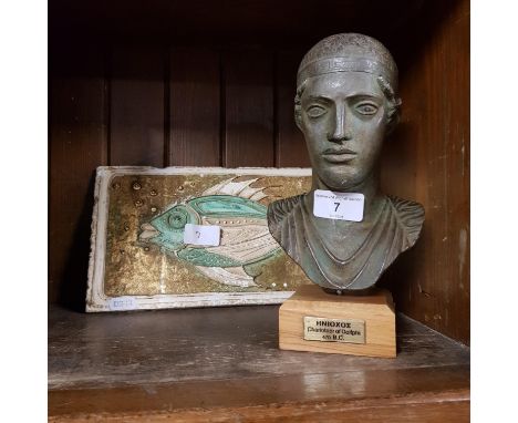 A bronze effect bust of an ancient Greek charioteer together with a ceramic plaque decorated with a fish. 