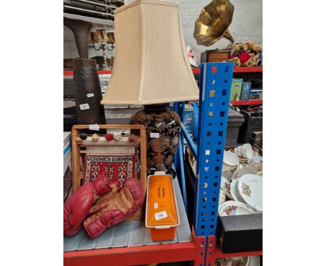 A modern table lamp with shade and a Le Cruset style orange pot. 