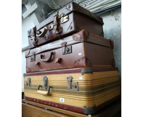 A group of three vintage suit cases. 