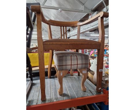 An oak armchair together with a modern footstool with plaid upholstery.