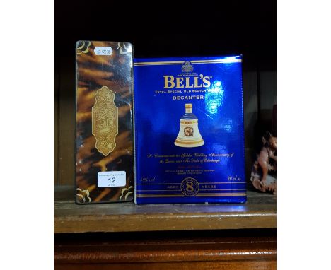 A Bell's Golden Wedding anniversary whisky decanter, boxed and sealed, together with a tin of dominoes.