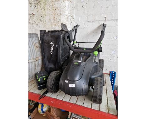 A Gtech cordless lawnmower with battery and charger. 