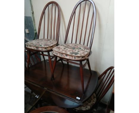 An Ercol dark elm drop leaf table and four Ercol 'Quaker' chairs. 