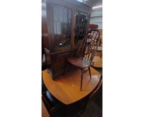 A mixed lot of furniture comprising a teak table and chairs, an Ercol chair and an Old Charm style bookcase.