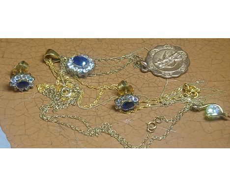 A mixed lot comprising a St Christopher pendant on chain, a CZ pendant on chain, a yellow metal pendant set with blue and col