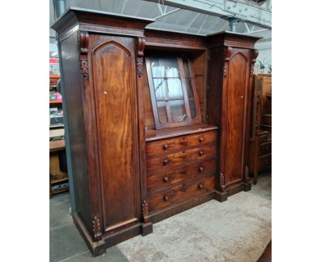 A 19th century mahogany breakfront wardrobe, circa 1840, central glazed cabinet above drawers, flanked either side by cabinet