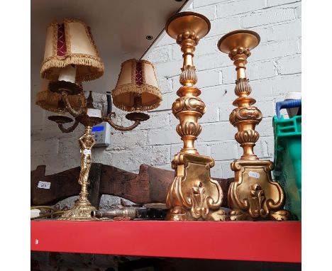 A three branch brass table lamp, two gilt candlesticks and a set of brass bellows.