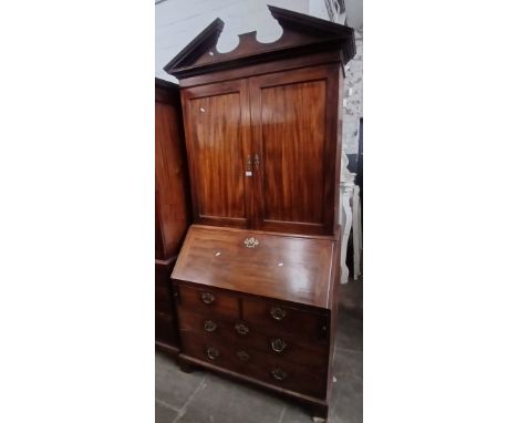 A George III mahogany cabinet bureau, architectural pediment, cabinet top with internal adjustable shelves, bureau base with 